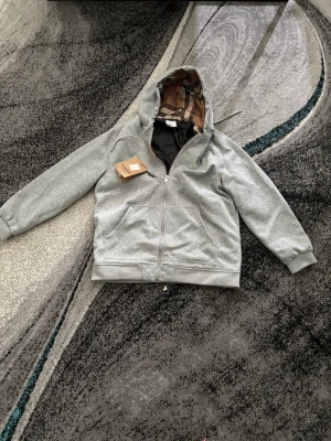 Grå burberry hoodie  - Helt ny och fin burberry hoodie.                                     Det står att den är i storlek XXL men den passar mig perfekt som L (Kan även passa XL)