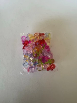 Ca 50 st färgglada nappar/berlocker - Säljer av material som jag använt för att göra smycken. Har 2025 tillverkat och sålt smycken för över 50.000kr så är något folk uppskattar (om man håller låga priser) . Nu har jag dock tappat intresset så säljer av allt jag har. Kolla gärna in andra annonser   I denna annons hittar du berlocker för smyckestillverkning 