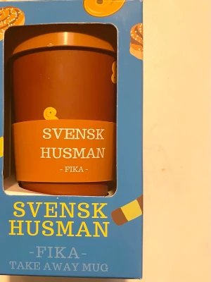 Svensk Husman Fika Take Away Mugg - Svensk Husman Fika Take Away Mugg. Tillverkad av 100% PLA med PLA-lock och silikonhylsa. Miljövänlig, BPA-fri, melaminfri och diskmaskinssäker.  Katter finns i hemmet!