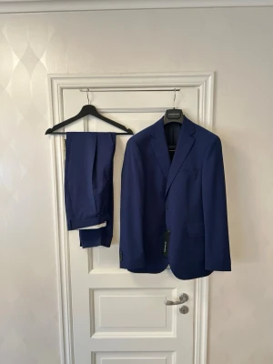 70% RABATT NY Eduard Dressler 48 marinblå kostym nypris 11 000kr - Exklusiv marinblå kostym i 100% ull från Eduard Dressler.  Nypris: över 11 000 kr Mitt pris: 3 200kr  Helt ny och oanvänd, i perfekt skick. Storlek: 48  Tidlös och välsittande modell – perfekt för student, bröllop, bal, examen eller arbete där kvalitet märks. Klassisk marinblå kostym i premiumull som fungerar året runt.  Kan fraktas eller provas i Sollentuna. Fler kostymer finns i andra storlekar och märken. Hör av dig vid intresse!
