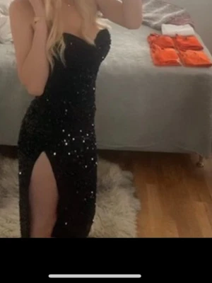Balklänning Svart glittrig - Säljer min svart glittriga balklänning med en slits på sidan. använd 1 gång. Köpte den för för ca 1000 så säljer den billigt