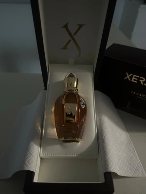 Xerjoff La Capitale Parfym 100ml - Lyxig parfym från Xerjoff, La Capitale, i en elegant guld- och bärnstensfärgad flaska med guldfärgat lock. Kommer i exklusiv presentförpackning med matchande ask. Flaskan har en unik, lyxig form och detaljer i metall. Kvittot finns på mejlen då den är beställd och flaskan är full! Endast doftat på den. Jättegod doft men lite för stark för mig.