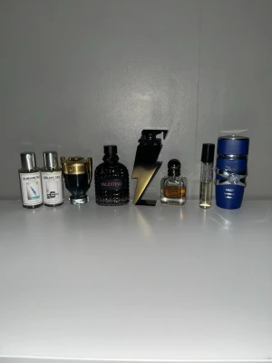 Mix av herrparfymer från kända märken - Säljer ett set med flera herrparfymer från märken som Valentino, Paco Rabanne, Dior, Armani, Versace och Carolina Herrera. Flakongerna har olika former och färger, bland annat svart, blå och guld. Perfekt för dig som vill testa olika dofter från exklusiva märken. Och för er som inte fattar så kostar den INTE 1 KR
