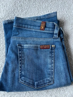 Blå bootcut jeans från 7 For All Mankind - Säljer ett par klassiska blå bootcut jeans från 7 For All Mankind. Tillverkade i mjuk denim med stretch. stl 25💕