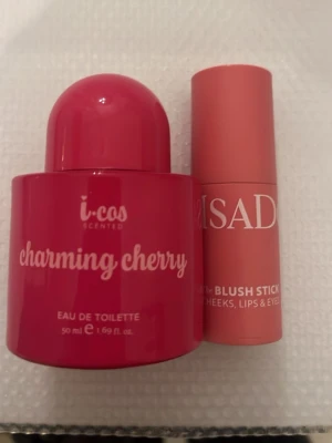 i-cos Charming Cherry Eau de Toilette - En söt och fruktig parfym från i-cos med namnet Charming Cherry. Flaskan är rund och knallrosa med vit text och har ett lock i samma färg. Volymen är 50 ml och doften är inspirerad av körsbär. Perfekt för dig som gillar färgstarka och lekfulla dofter.