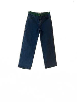 Blå jeans med gröna detaljer - Unika blå jeans med raka ben och gröna paneler baktill samt grön linning. Märkes byxor köpa i Italien för några veckor sedan men passade tyvärr inte, så är i princip så gott som nya! Klassisk femficksmodell i denim med cool kontrastfärg som sticker ut. Perfekta för dig som vill ha något annorlunda i garderoben.