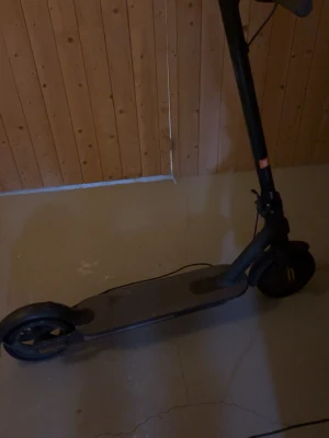 Svart elscooter med digital display - Säljer en svart elscooter med digital display på styret. Scootern har handtag med greppvänligt material, ringklocka och orange knapp. Perfekt för att ta sig runt snabbt och smidigt. Laddningsbar och enkel att använda.