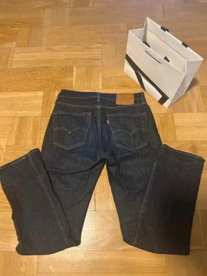 Levis jeans 514 - Säljer ett par mörkblåa Levis jeans modell 514. Använda endast ett fåtal gånger, inga tecken alls på användning. Extremt bra skick. Storleken är W30 L32. OBS! Påsen i bilderna följer inte med vid köp av jeansen. Bara att höra av sig vid frågor mm.