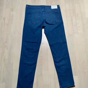 Blå jeansbyxor - Snygga blå jeansbyxor med klassisk design. De har en knappgylf och femficksmodell. Perfekta för en avslappnad stil.Hugo Red modell 634 strl 33/34