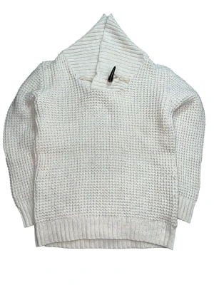 Vit stickad tröja med sjalkrage - Säljer en vit stickad tröja med grov struktur och sjalkrage. Tröjan har långa ärmar och ribbade muddar vid ärmslut och nederkant. Perfekt för kyliga dagar och enkel att matcha med olika outfits. Armlängd 43 cm, längd på tröjan 55 cm och bredd 38 cm