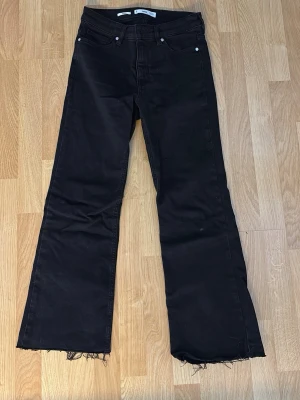 Svarta flare jeans från MNG - Snygga svarta flare jeans från MNG, modell Sienna. Jeansen har råa, fransiga benslut och klassisk femficksdesign. Tillverkade i ett mjukt denimtyg som ger en skön passform och trendig look.