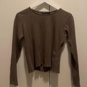 Brun långärmad topp - Superfin brun topp med lite mönster. Toppen har två små hål vid ena ärmen som man kan se i andra bilden men det är inget märkvärdigt! 😊