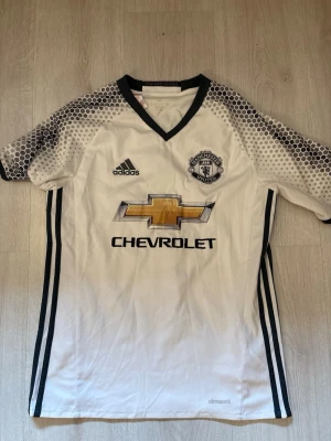 Man United tröja Pogba 6 - En Manchester United bortatröja från säsongen 2016/17. Pogba 6 på ryggen. Det är en stor barnstorlek 176. Så gott som S.