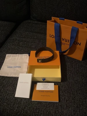 Louis Vuitton svart monogram-armband - Säljer ett lv armband i helt okej skick, använt kanske 10-15 gånger. Hålen är lite sträckta men det är bara sista hålet och det påverkar inte så mycket heller. Skriv om binär intresserade 