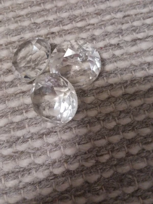 Tre klara glasstenar till modeprojekt - Säljer tre transparenta glasstenar med slipad, oval form. Perfekta för att dekorera. Stenarna har en kristalliknande look och reflekterar ljuset snyggt.