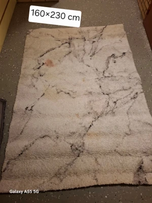 Vit matta med marmormönster - Säljer en stor rektangulär matta i vitt med svart marmormönster. Mattan mäter 160x230 cm och har en mjuk, fluffig yta som ger ett modernt intryck till rummet. Perfekt för att skapa en mysig känsla i vardagsrummet eller sovrummet. Behöver tvätta 