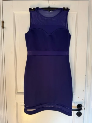 Mörkblå klänning  - Snygg mörkblå midiklänning med meshdetaljer upptill och vid fållen. Klänningen är ärmlös och går ner till knähöjd. Perfekt för dig som vill ha en stilren och modern look.