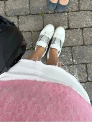 Grå Valentino Garavani sneakers - Säljer ett par vita sneakers från Valentino Garavani med grått band över mitten och nitar på sulan. Skorna har en klassisk låg siluett och är tillverkade i läder med detaljer i gummi. Perfekta för dig som gillar exklusiv streetstyle. Säljer pga har köpt nya❣️