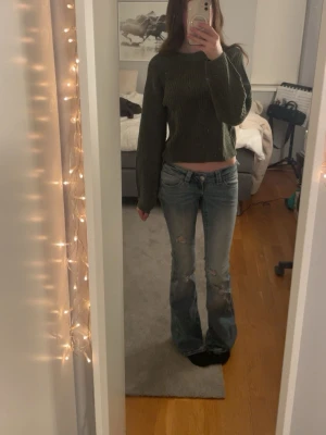 Grön stickad tröja - Säljer en grön stickad tröja med grov ribbstickning och rund hals. Tröjan har långa, lite vidare ärmar och breda muddar vid ärmslut och nederkant. Perfekt för lager på lager och riktigt mysig till hösten. Bekväm och matchar till allt!