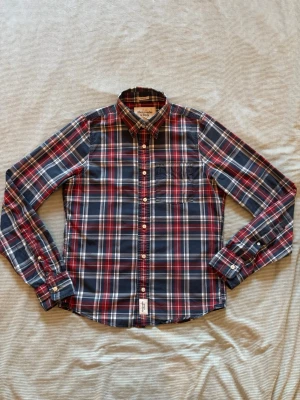 Rutig skjorta från Abercrombie & Fitch - Säljer en snygg rutig skjorta från Abercrombie & Fitch i storlek M. Skjortan är i fint skick och passar perfekt både till vardag och lite mer uppklätt.    Passar mig bra som är ca 178 cm lång, så den sitter slim/lite lösare.    Pris: Bud kan diskuteras – inte hugget i sten 👍    Hör av dig vid intresse eller frågor 🙂