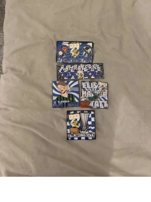 IFK Göteborg tygmärken samling - Samling med fem tygmärken i blått och vitt med olika IFK Göteborg-motiv. Märkena har text och illustrationer som 'Kamraterna', 'Västkusten', 'Internationa', samt supporter- och rivalmotiv. Perfekt för att pimpa jackan eller väskan.