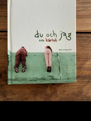 Du och jag om kärlek - En bok med dikter och texter om kärlek, skrivna av både kända författare och unga. Omslaget är vitt och grönt med ett foto av två personer som ligger på en mur. Perfekt för dig som vill läsa om känslor och relationer.