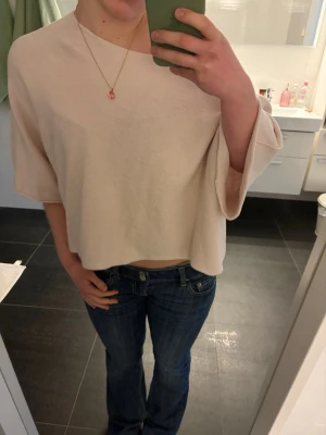 Rosa off the shoulder topp med vida ärmar - Säljer en rosa off the shoulder topp med vida trekvartsärmar och lös passform. Toppen har en enkel, minimalistisk design och är tillverkad i ett mjukt tyg som känns skönt mot huden. Perfekt för en avslappnad och trendig look.