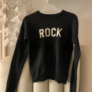 Svart tröja från Zadig & Voltaire - Säljer en svart tröja från Zadig & Voltaire med texten 'ROCK' i vitt på framsidan. Tröjan är i bra skick och har långa ärmar. Perfekt för en cool och avslappnad stil. Passar både till vardags och fest!🌸nypris: 1300! Använd men i mycket bra skick 🥰