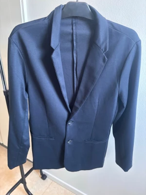 Blå kavaj - Hej, Säljer denna mörkblåa kavajen då den inte kommer till användning. Använd ett fåtal gånger och är i väldigt fint skick. Passar mig bra på 183cm lång.