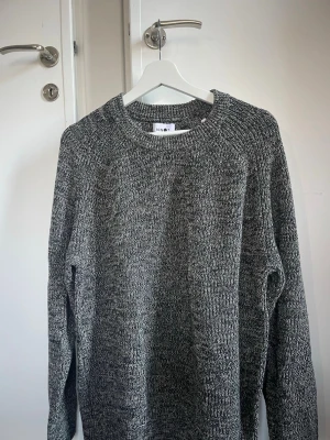 Gråmelerad stickad tröja från NN07 - Säljer en gråmelerad stickad tröja med rund halsringning. Tröjan är nästan aldrig använd och i bra skick. 100% bomull