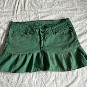 Grön volangkjol  - För stor för modellen! Midjemått rakt över: 42 cm