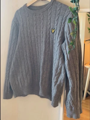 Grå kabelstickad tröja Lyle & Scott - Snygg grå kabelstickad tröja från Lyle & Scott. Funkar som XS okså! Hör av dig vid funderingar🔥👊