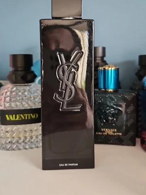 YSL svart Eau de Parfum - Snygg parfymflaska från Yves Saint Laurent i svart, rektangulär design med YSL-loggan i relief på framsidan. Flaskan har en modern och stilren look som passar perfekt på parfymhyllan. Eau de Parfum-variant.
