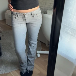 LTB bootcut jeans - Säljer ett par ljusgrå bootcut jeans med klassisk femficksdesign och låg midja. Midjemått: 37cm rakt över , Innerbenslängd: 78cm 