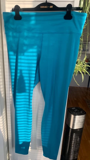 Turkosa träningstights med hög midja, H&M - Snygga turkosa leggings med hög midja och tight passform. Tillverkade i ett stretchigt och mjukt material som passar perfekt för träning eller chill. Inga synliga loggor eller mönster, bara clean look.