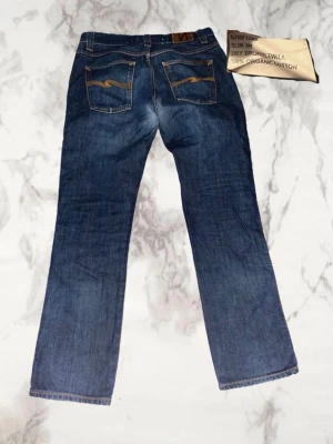 Nudie Slim Jim - Säljer dessa väldigt snygga nudie slim Jim jeans ( slim bootcut ). Storlek 32/32 men sitter mer som 31/32. Mått:  Midja: 40 Ytterben: 100 Benöppning: 19  Pris kan diskuteras 😊