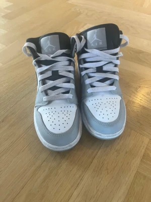 Nike Air Jordan 1 Mid grå/vit - Säljer ett par Nike Air Jordan 1 Mid sneakers i grått och vitt med svarta detaljer. Använd få tal gånger men i väldigt bra skick 