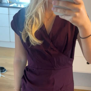 Festklänning - Supersnygg festklänning i vinröd med v ringning och detaljer 