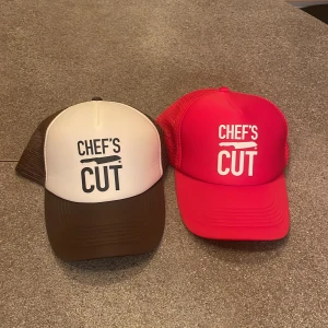 150 KR STYCK.  Chef's Cut truckerkeps brun och röd - Två snygga truckerkepsar från Chef's Cut, en i brunt och vitt och en i rött. Båda har vit tryckt logga framtill och mesh på sidorna för extra ventilation. Justerbar passform bak och klassisk böjd skärm. Perfekt accessoar för en avslappnad stil.