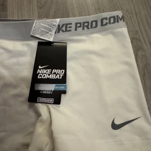 Nike Pro Combat vita träningsshorts - Nike Pro Combat vita kompressionsshorts . HELT NYA MED LAPP!! Storlek S. Pris kan diskuteras och skriv om frågor och funderingar💕💕
