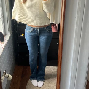 Blå bootcut jeans låg midja - Säljer ett par snygga blå jeans med bootcut och låg midja. Jeansen har klassisk femficksdesign, dragkedja och knapp framtill. Materialet är jeans med lätt stretch för skön passform. Perfekta för dig som gillar en avslappnad men ändå trendig look.