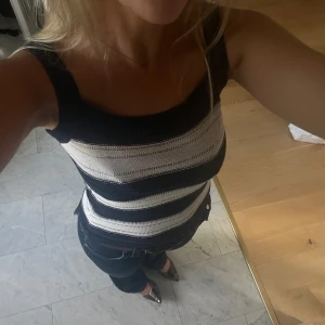 Randig stickad linnetopp i blått och vitt - Säljer en snygg stickad linnetopp med breda axelband och raka kanter. 