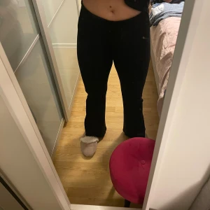 Svarta bootcut byxor från KappAhl - Snygga svarta bootcut byxor från KappAhl i storlek S. De har medel hög midja och en stilren söm framtill som ger en schysst siluett. Materialet är mjukt och stretchigt, perfekt för dig som vill ha både komfort och stil. Passar dig som gillar klassiska svarta byxor med lite extra edge.