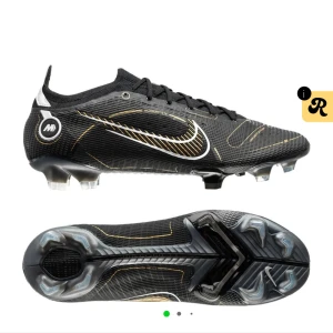Helt nya slutsålda Nike Mercurial svarta fotbollsskor - Svarta Nike Mercurial fotbollsskor med guldiga och silvriga detaljer som tyvärr inte passade. Skorna har snörning, låg profil och en platt sula med dobbar för bästa grepp på planen. Swoosh-loggan syns tydligt på sidorna och materialet är syntet för lätt känsla och bra passform.