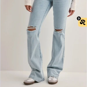Nelly low waist jeans  - Nelly lågmidjade jeans med hål och rosa detaljer på fickorna, använda kanske tre gånger.