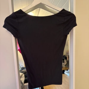 Grå topp med öppen rygg - Grå topp med korta ärmar och en djup, öppen rygg. Lite nopprig