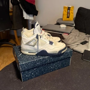 Nike Air Jordan 4 Retro OG Vit/Marin - Säljer ett par Nike Air Jordan 4 Retro OG i vit och marinblå med röda detaljer under sulan. Jag säljer dem då min kille inte använder dem längre de är i väldigt bra skick men tecken på användning. Kvitto och karton fås med