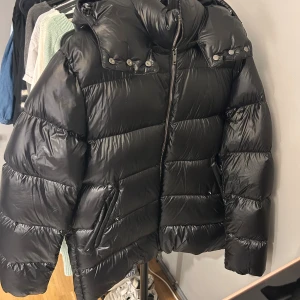 Svart pufferjacka från Massimo Dutti - Säljer min superfina dunjacka från Massimo dutti som jag köpte förra vintern.storlek L men sitter bra på mig som har M vanligtvis. Säljer då jag inte använde den förra vintern. Nypris: 2500