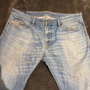 Ljusblå jeansshorts  från Diesel, storlek W 36 - Säljer ett par ljusblå jeansshorts  från Diesel i klassisk femficksmodell. Jeansen har snyggt slitna detaljer, raka ben och normal passform. Materialet är mjukt denim i bomull och de har en ikonisk Diesel Industry-lapp på myntfickan.