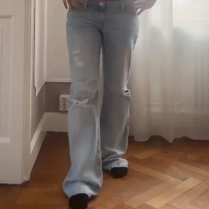 Ljusblå bootcut jeans med slitningar - Säljer ett par ljusblå jeans med bootcut passform och snygga slitningar på knäna och låren. Dem är ifrån Gina Young+ i storlek 164 xs. Jeansen var för stora på mig så säljer dem. Helt nya med prislapp kvar. Innerbenet 81 cm och midjan ca 36 cm. Bilderna är inte mina!!nypris 400kr